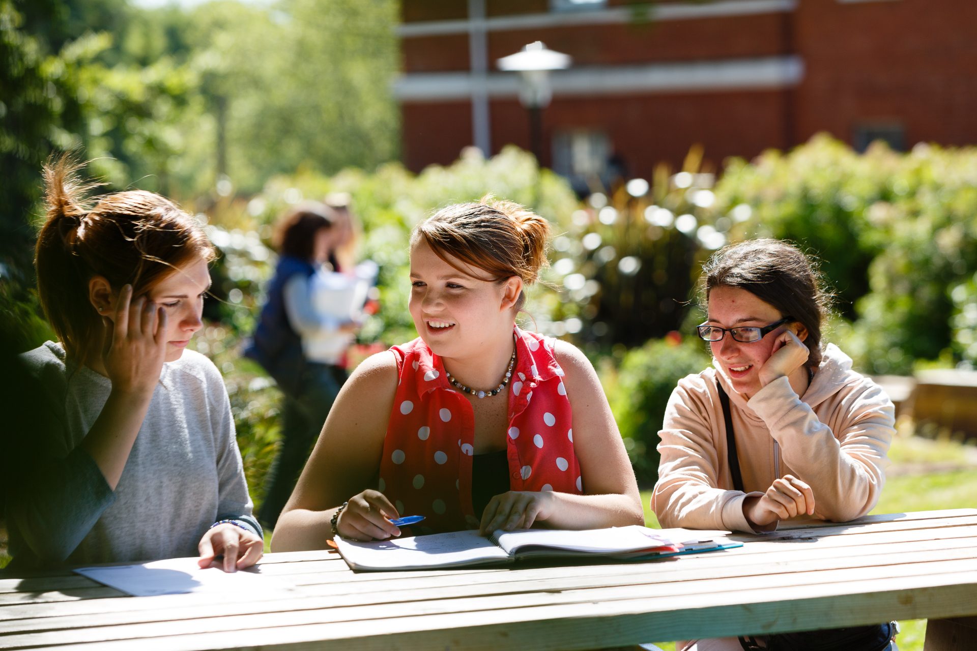 Three students chatting outdoors on campus